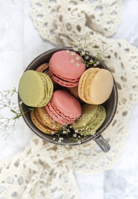 Macarons with dried flowers in mug, top view — Stock Photo