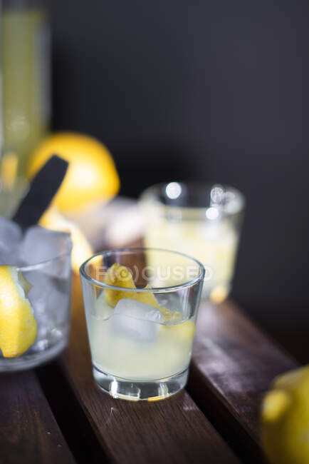 Limoncello con cubitos de hielo y cáscara de limón fresca - foto de stock