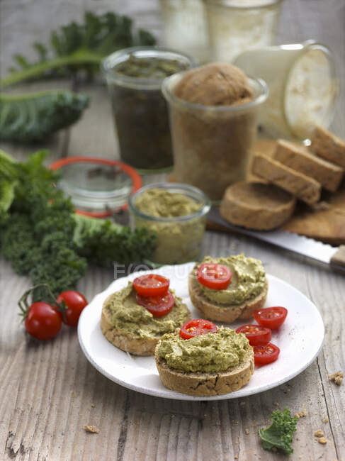 Kale cream and cherry tomatoes on country bread — Stock Photo
