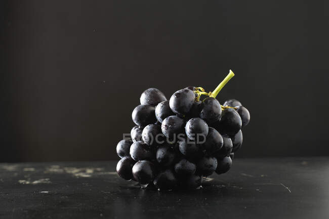 Uvas vermelhas em vinho no fundo escuro — Fotografia de Stock