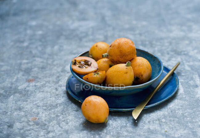 Close-up de deliciosos frutos Medlar em tigela azul — Fotografia de Stock