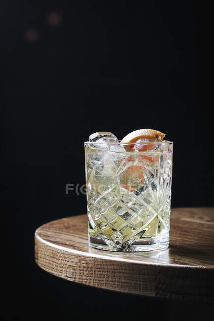Cocktail de gim com fatias de toranja e gelo em vidro — Fotografia de Stock