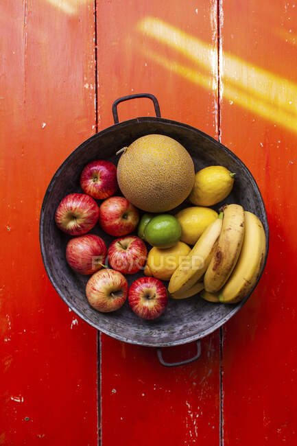 Яблоки, лимоны, бананы и дыня в миске с фруктами — стоковое фото
