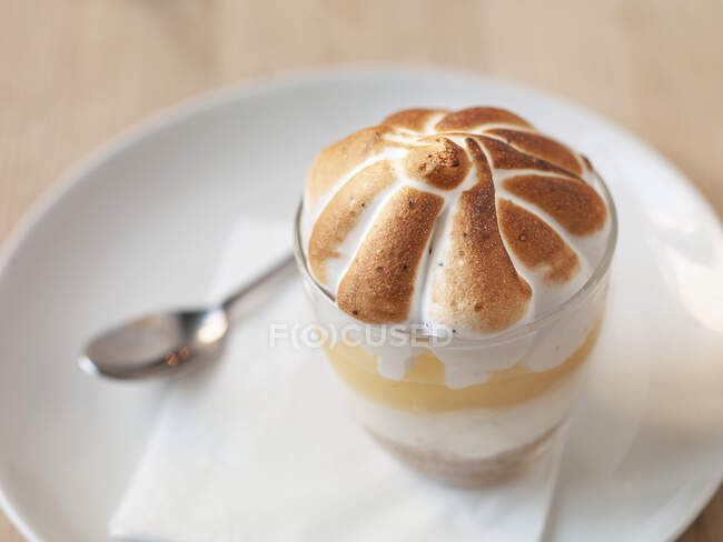 Dessert di meringa in vetro con cucchiaio sul piatto — Foto stock