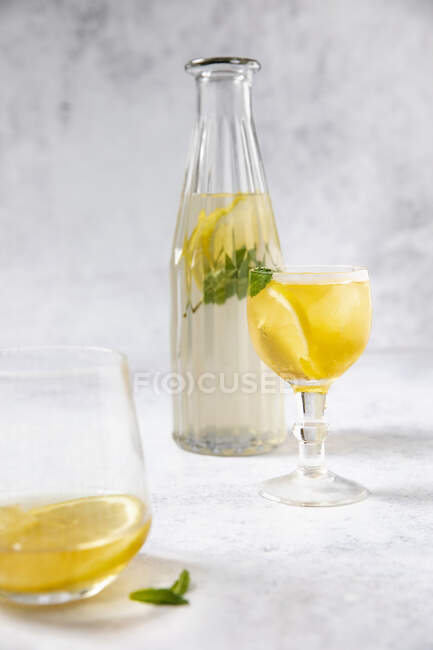 Cold peppermint tea with lemon in a glass bottle — Stock Photo