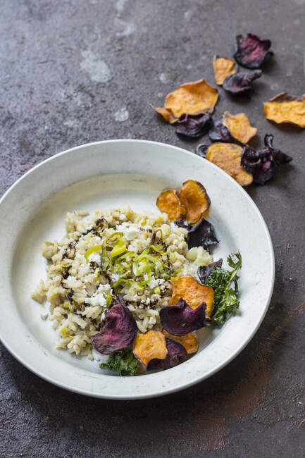 Leek and goat cheese risotto with balsamic vinegar, beetroot, sweet potatoes and kale crisps — Stock Photo