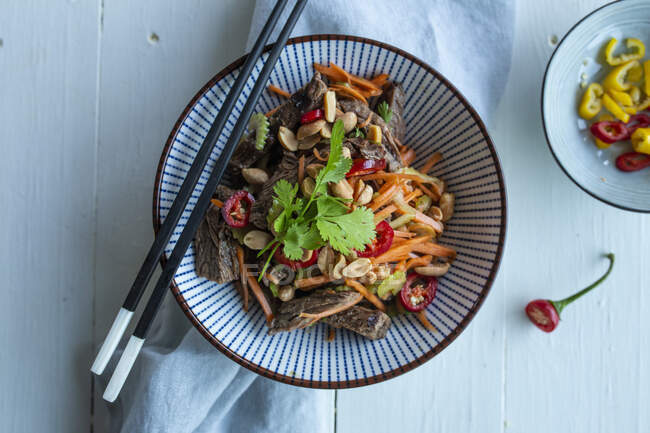 Азиатский салат из говядины с овощами и арахисом — стоковое фото