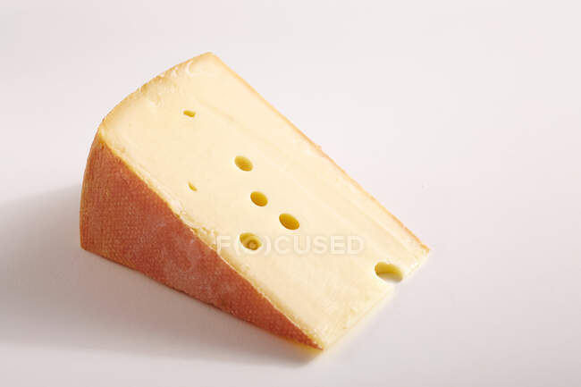 Trozo grande de queso en la superficie blanca - foto de stock