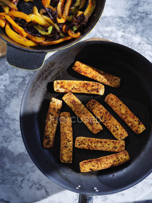 Pan fried marinated tofu with pan fried peppers and onions — Stock Photo