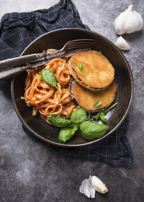 Aubergine cutlet with ribbon pasta in tomato sauce — Stock Photo