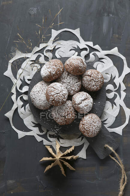 Gluten free hazelnut biscuits with icing sugar on round wooden board — Stock Photo