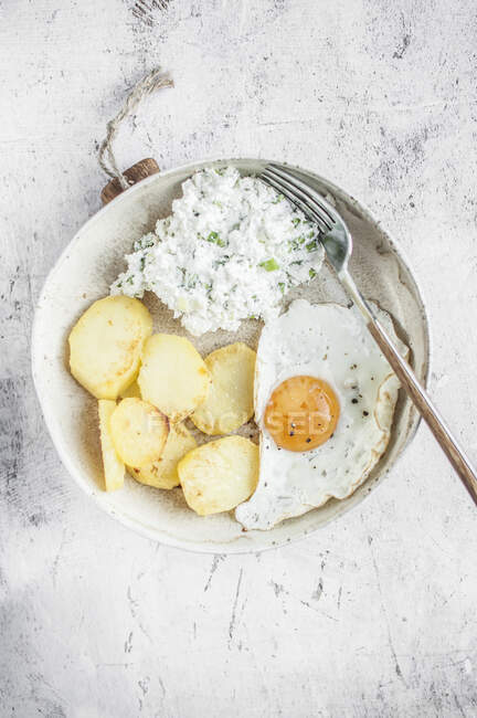 Simple vegetarian lunch. Fried egg, fried potatoes and cottage cheese with green onion. — Stock Photo