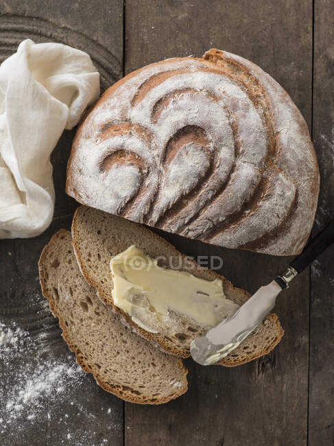 Sliced bread with bread and knife and loaf — Stock Photo