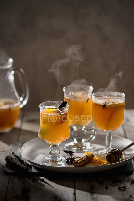 Hot mulled apple juice with spices, cinnamon, cloves, star anise, orange slices and zest — Stock Photo