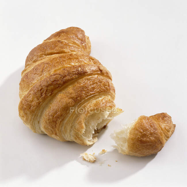 Primer plano de Croissant, roto en blanco - foto de stock