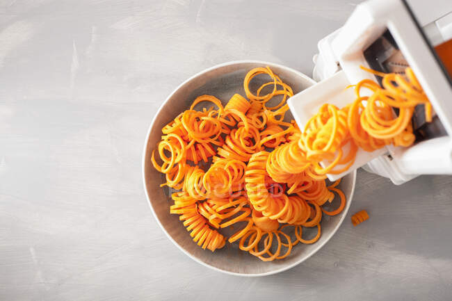 Pasta with raw carrots and tomato on a wooden background. top view. — Stock Photo