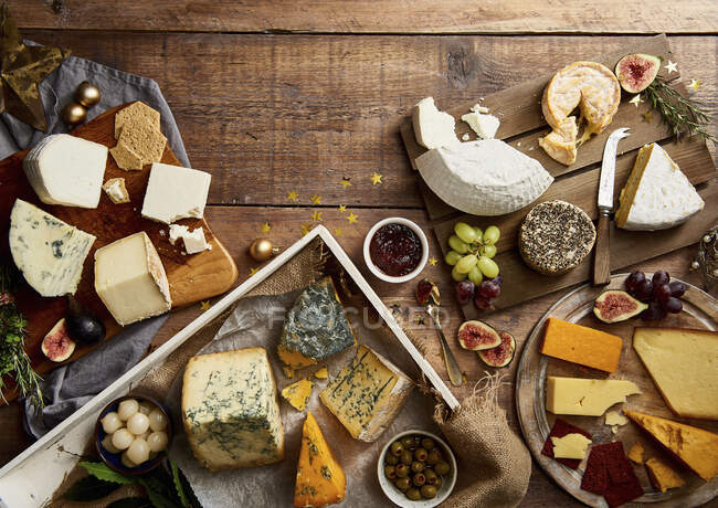 Selection of cheeses with fruit, crackers, herbs and chutney — Stock Photo