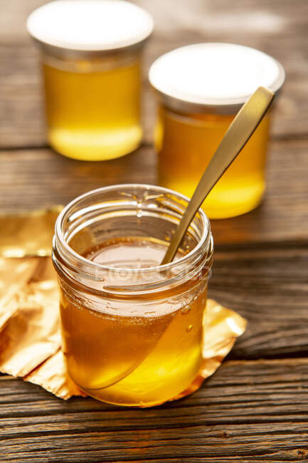 Honey in jars on rustic wooden surface — Stock Photo