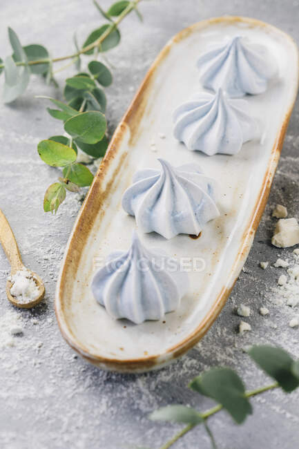 Pequenos merengues azuis na placa longa — Fotografia de Stock