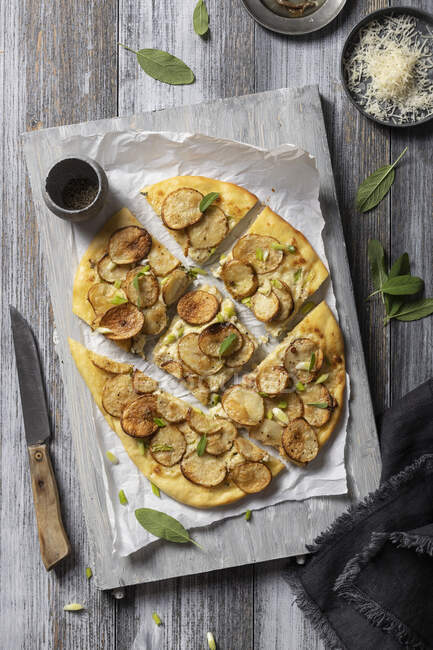 Pizza bianca with potatoes, sage, spring onions, parmesan and anchovies — Stock Photo