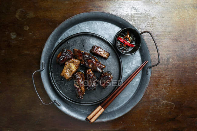 Карамельные свиные ребрышки с палочками для еды и соусом — стоковое фото