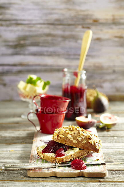 Cherries and figs jam on wholemeal bread with butter — Stock Photo