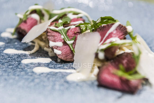 Rare roasted beef fillet with rocket and sauce Hollandaise — Stock Photo
