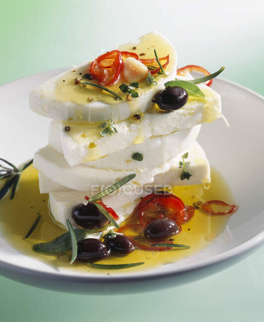 Queso feta marinado con aceite de oliva, chiles, aceitunas y romero - foto de stock
