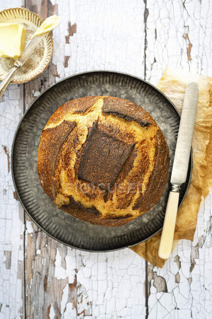 Хлеб из белого теста на металлическом подносе с ножом — стоковое фото