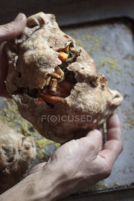 Close up of a man's hand holding a piece of bread — Stock Photo