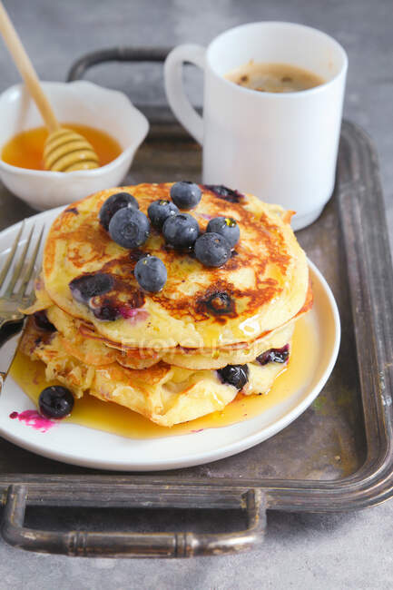 Blueberry pancakes served with honey and barley coffee — Stock Photo