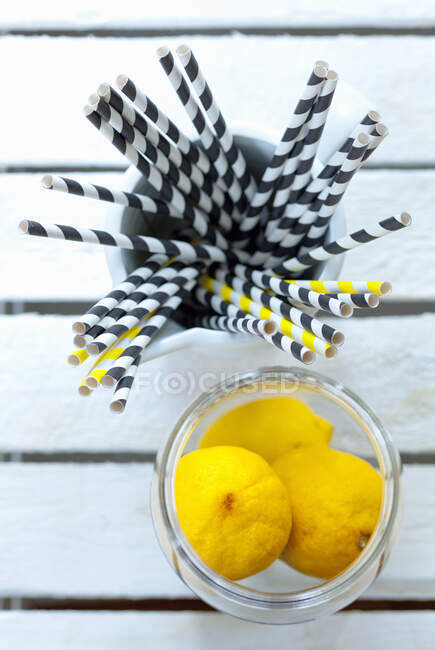 Straws and lemons as utensils and ingredients for drinks — Stock Photo
