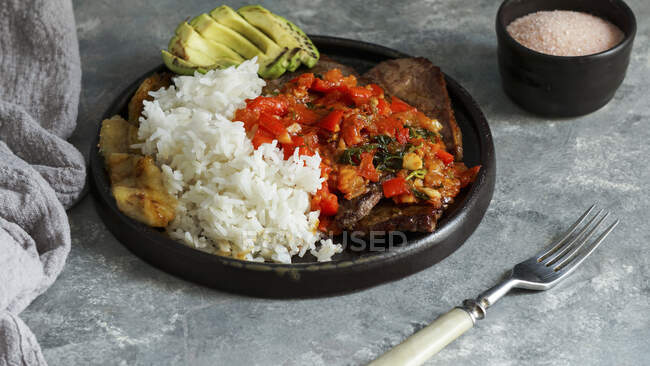 El Bistec a la Criolla - steak de boeuf colombien avec sauce tomate, riz, avocat, frites de bananes — Photo de stock