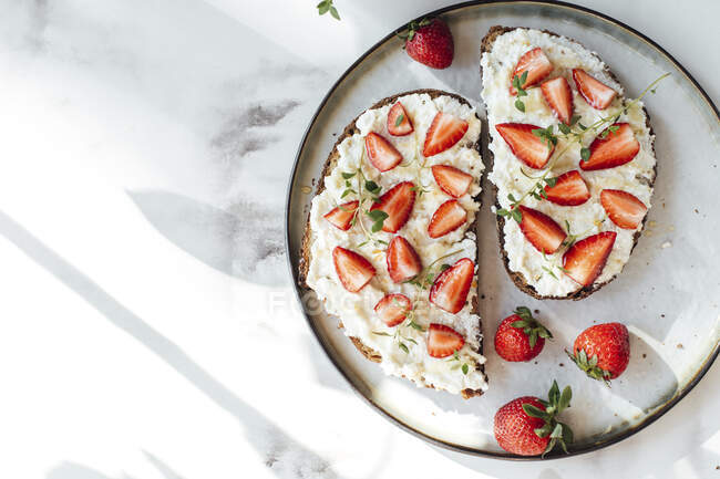 Bread with orange ricotta, strawberries, honey and thyme — Stock Photo