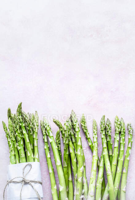 Green asparagus with and without wrapping, top view — Stock Photo