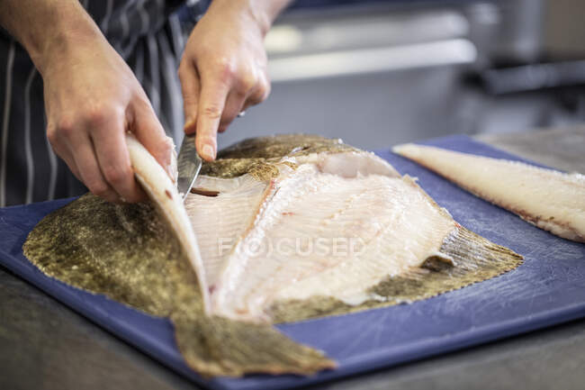 Tiro recortado de chef preparando pescado crudo para cocinar - foto de stock