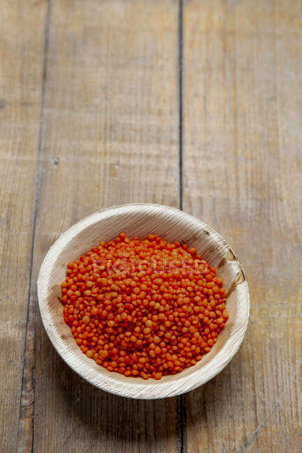Lentilles rouges dans un bol en bois — Photo de stock