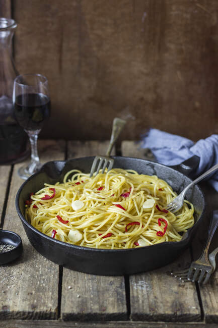 Spaghetti aglio, olio e peperoncino, blach pepper, red wine (Italy) — Stock Photo