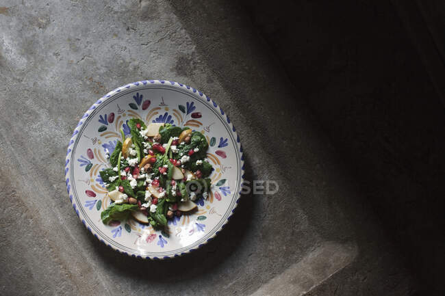 Pomegranate winter salad with feta, hazelnuts, spinach and pear — Stock Photo