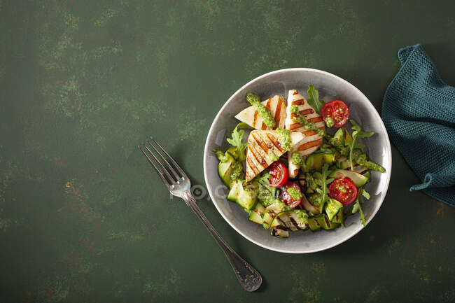 Courgettes salad with grilled halloumi, tomatoes and pesto — Stock Photo