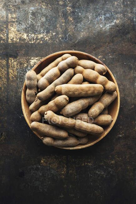 Close-up shot of delicious Tamarinds in a wooden bowl — Stock Photo