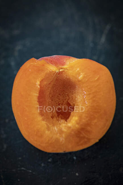 Nahaufnahme einer Aprikosenhälfte auf dunklem Hintergrund — Stockfoto