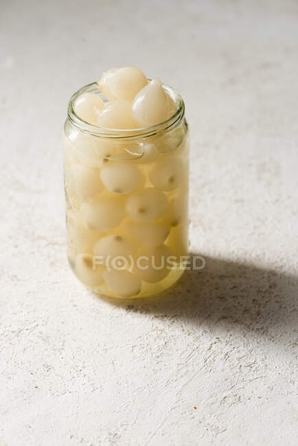 Cebolas pequenas conservadas em escabeche em um jarro — Fotografia de Stock