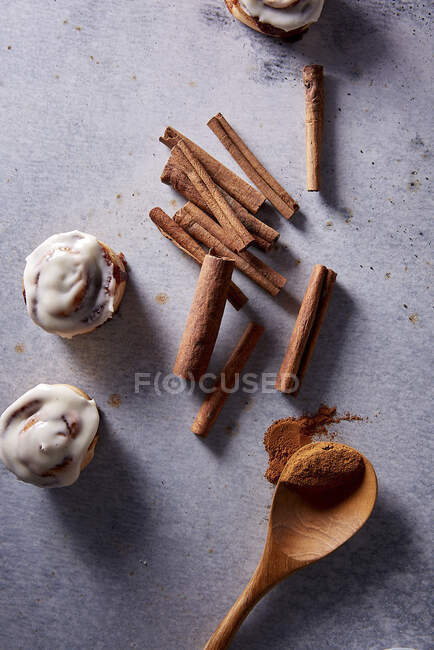 Mini cinnamon rolls and cinnamon sticks — Stock Photo