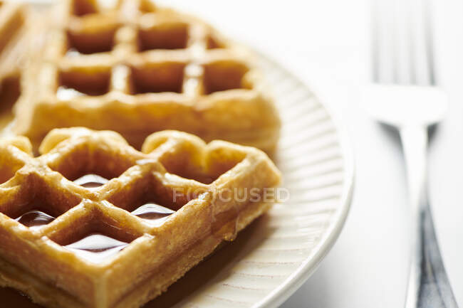 Belgas waffle peças com xarope drpping para baixo lado — Fotografia de Stock