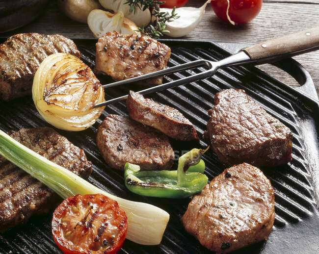 Várias carnes e verduras em uma grelha — Fotografia de Stock