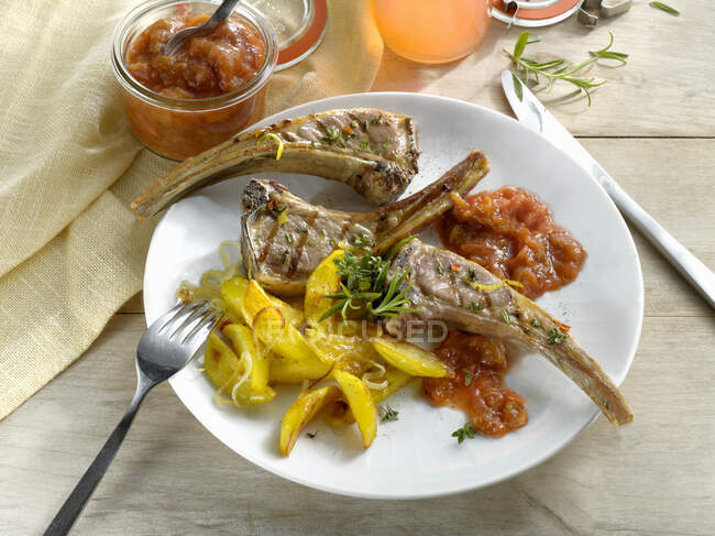 Grilled lamb chops with potatoes and sauce — Stock Photo