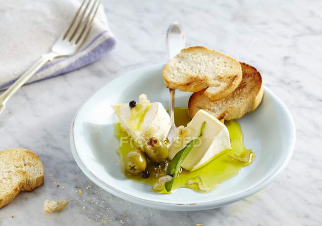 Marinato cremoso Camembert con olive, cipolla e salvia servito con baguette alla griglia — Foto stock