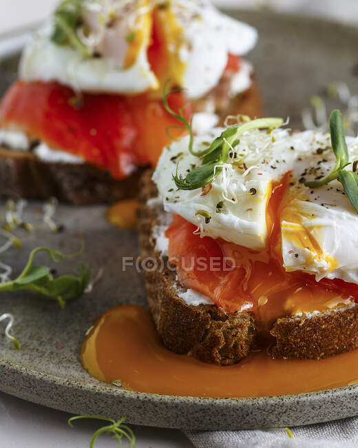 Bruschettas with cream cheese, salmon and poached eggs - foto de stock