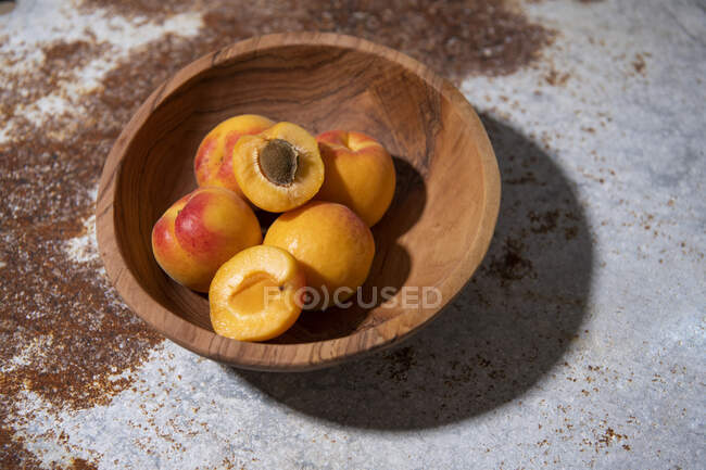 Frische Aprikosen in Holzschale auf rustikaler Metalloberfläche — Stockfoto
